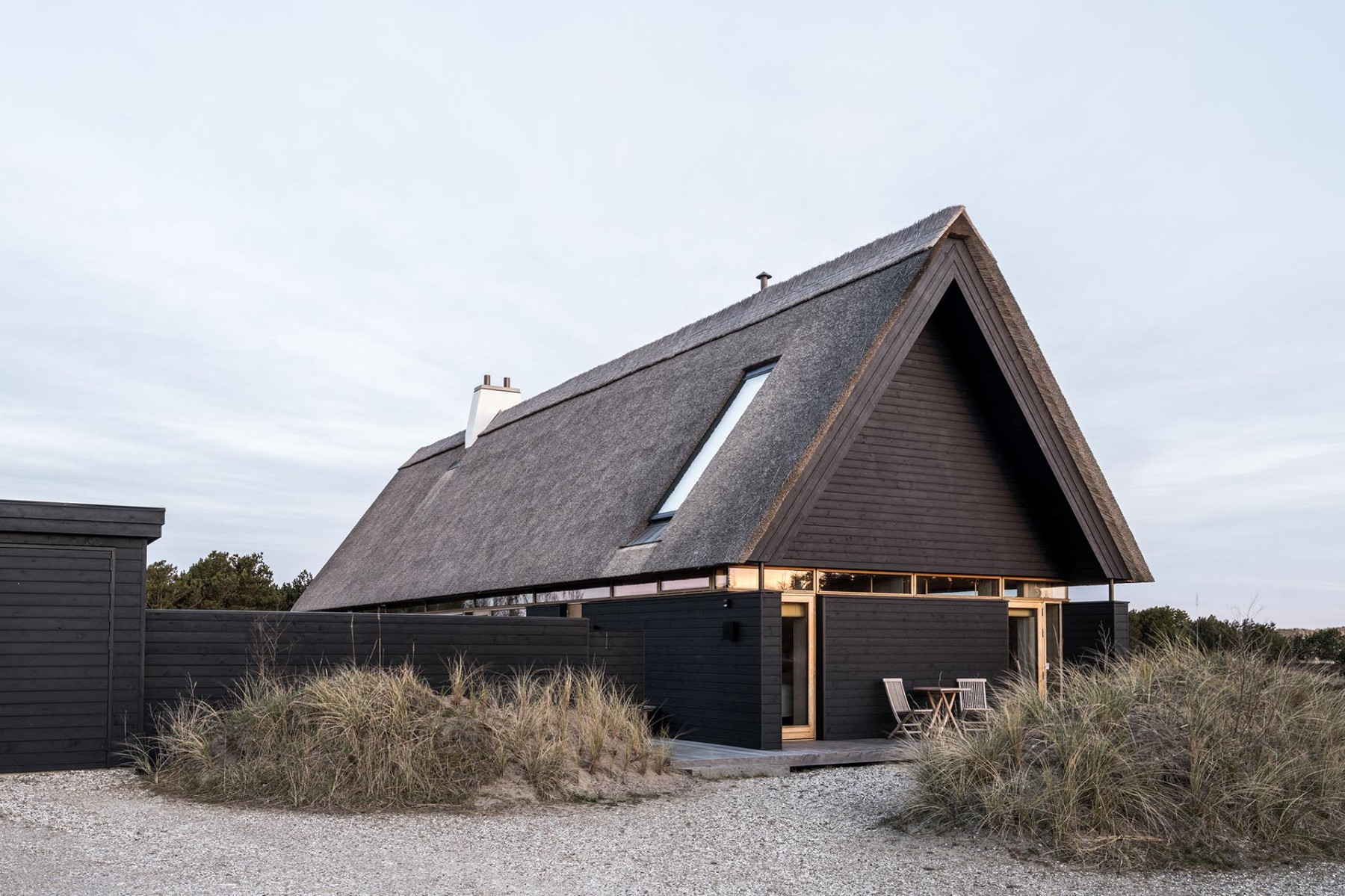 Třígenerační letní dům navrhli tradičně s doškovou střechou a opáleným dřevem jako když se v Jutlandu stavělo z lodních vraků