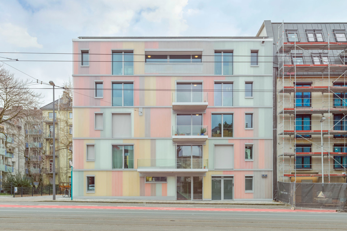 Družstvo si postavilo dům, kde nikdo nechtěl bydlet, malé byty nemají kuchyň, zato je tam školka a sdílené elektromobily